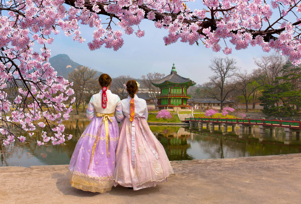 Cherry Blossom in spring with Korean national dress at Gyeongbokgung Palace Seoul,South Korea. - Foto: Shutterstock - Reis&Co